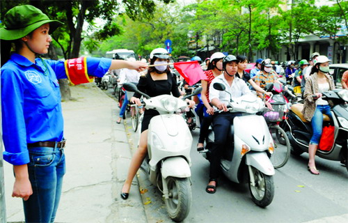 Thanh niên tình nguyện làm nhiệm vụ tại nút giao thông Huỳnh Thúc Kháng - Nguyên Hồng. 